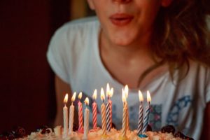 ילדה נושבת נרות ביום ההולדת שלה